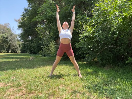 Personal trainer demonstrating sky and earth exercise. 