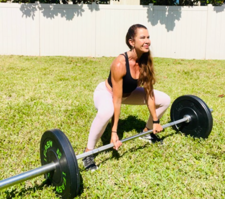 Personal trainer demonstrating sumo deadlift