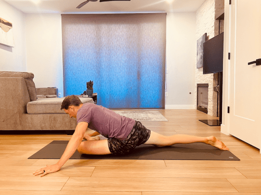 Physical therapist demonstrating active pigeon pose stretch 