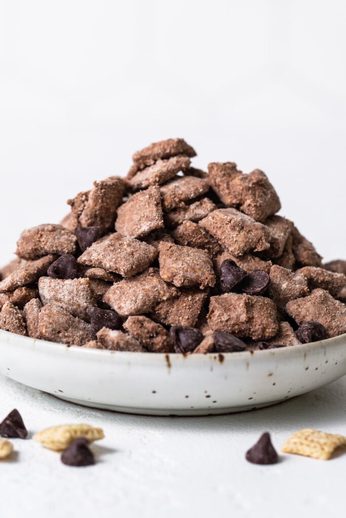 A bowl of chocolate cheetos on a white background.