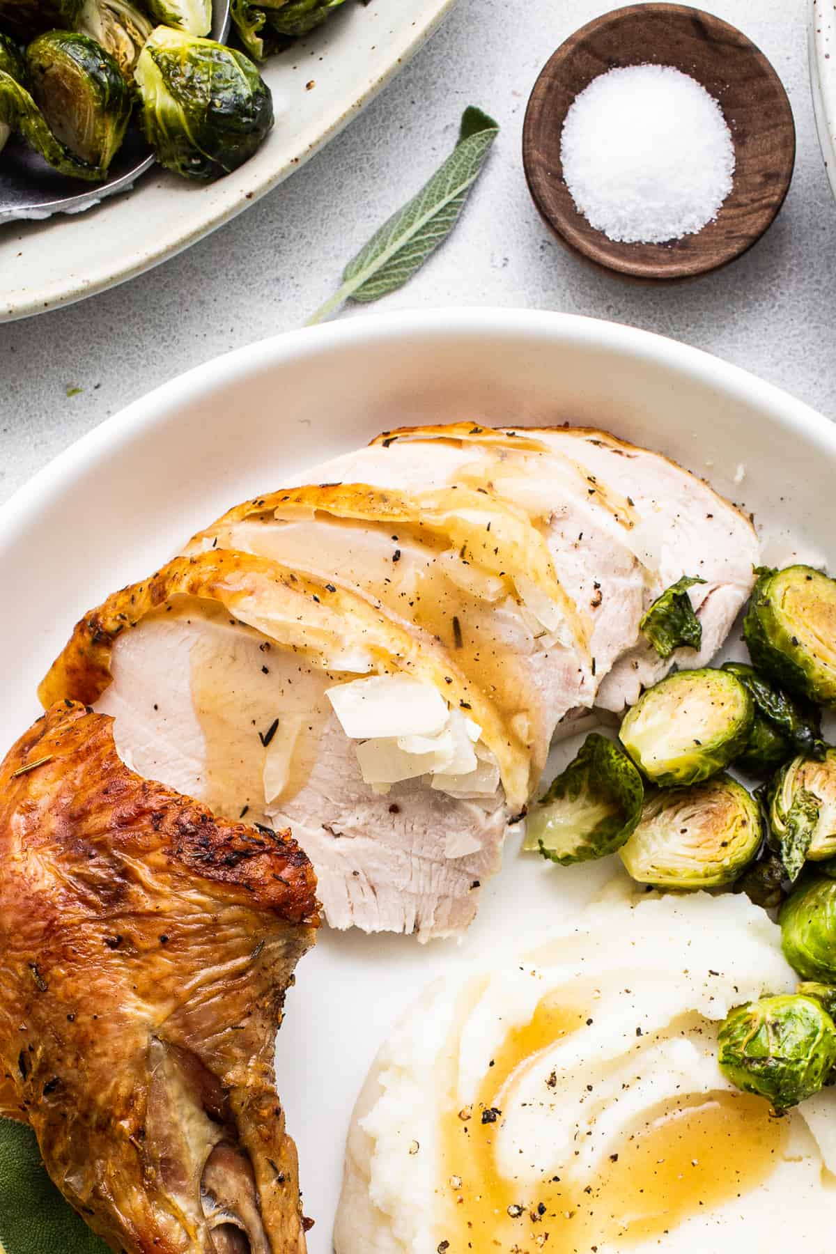 Sliced turkey and mashed potatoes on a plate.