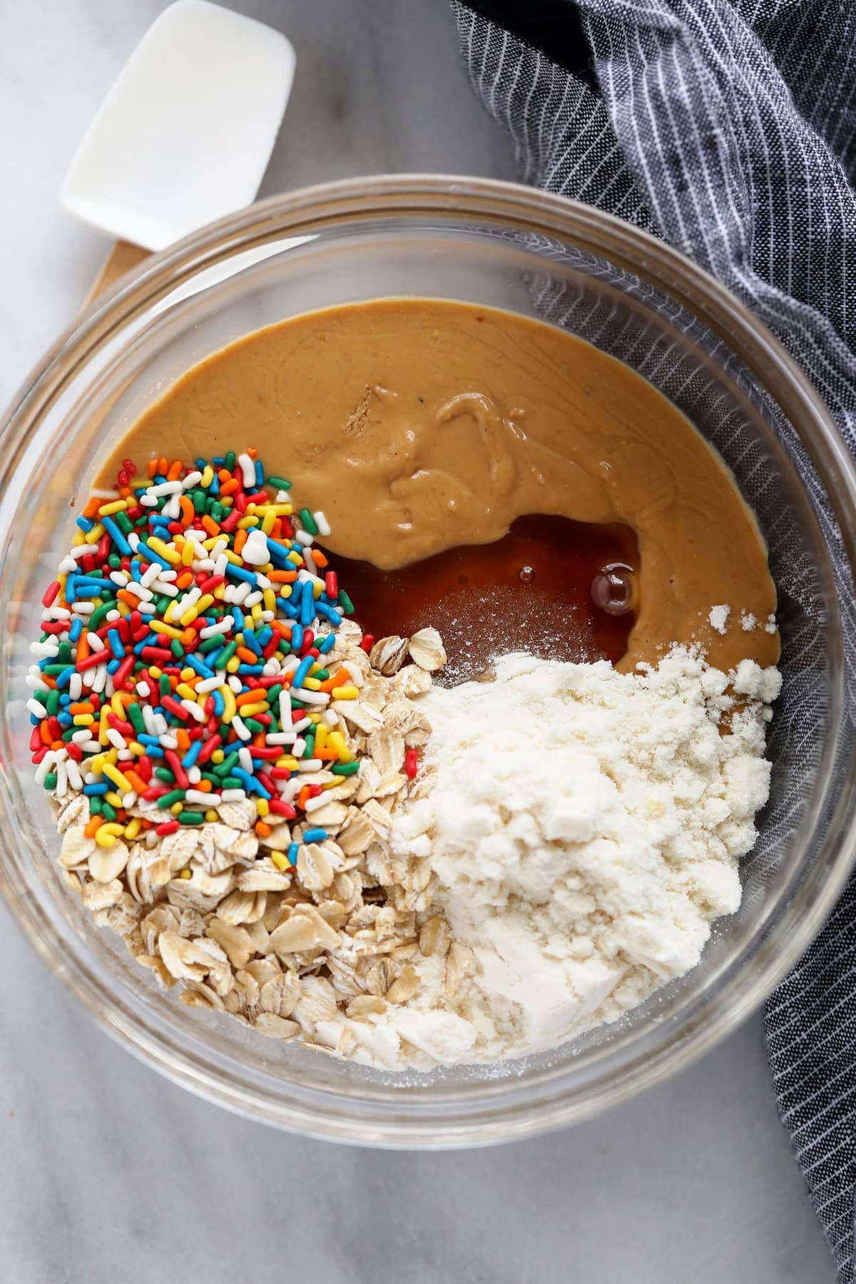 These super flavorful Cake Batter Protein Balls are energy packed from 6 simple ingredients. And no food processor required! cake batter protein ball ingredients in a bowl ready to be mixed
