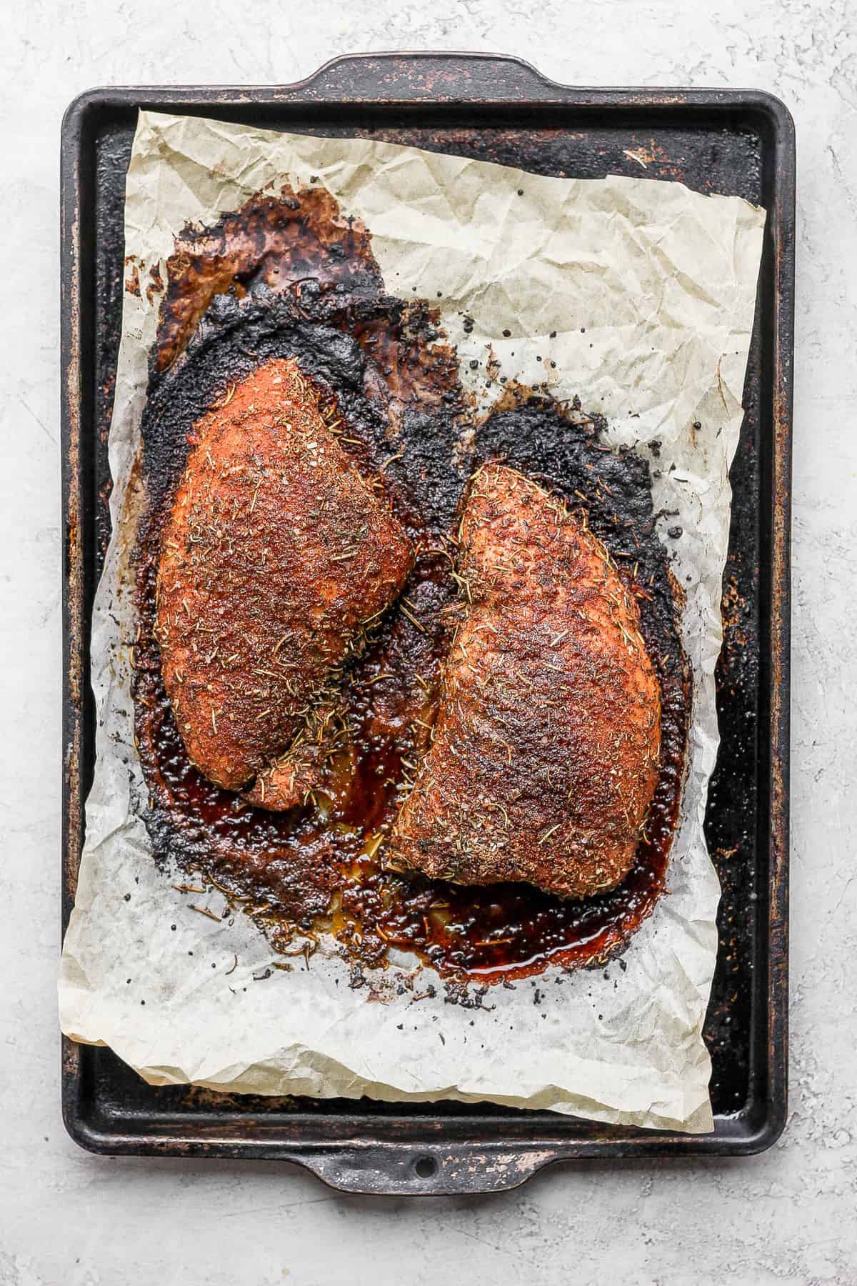 This easy baked turkey tenderloin is made super flavorful with a turkey brine and then our amazing turkey seasoning. Enjoy! baked tenderloin on baking sheet.