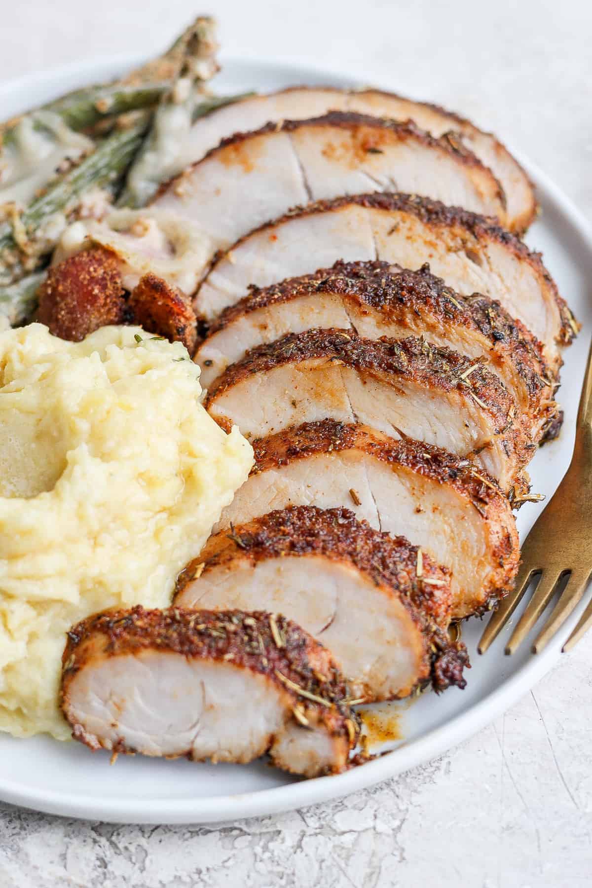 Make this juicy baked turkey tenderloin for Thanksgiving or an easy weeknight meal. It's made with a simple turkey brine and tasty turkey dry rub! sliced turkey tenderloin.