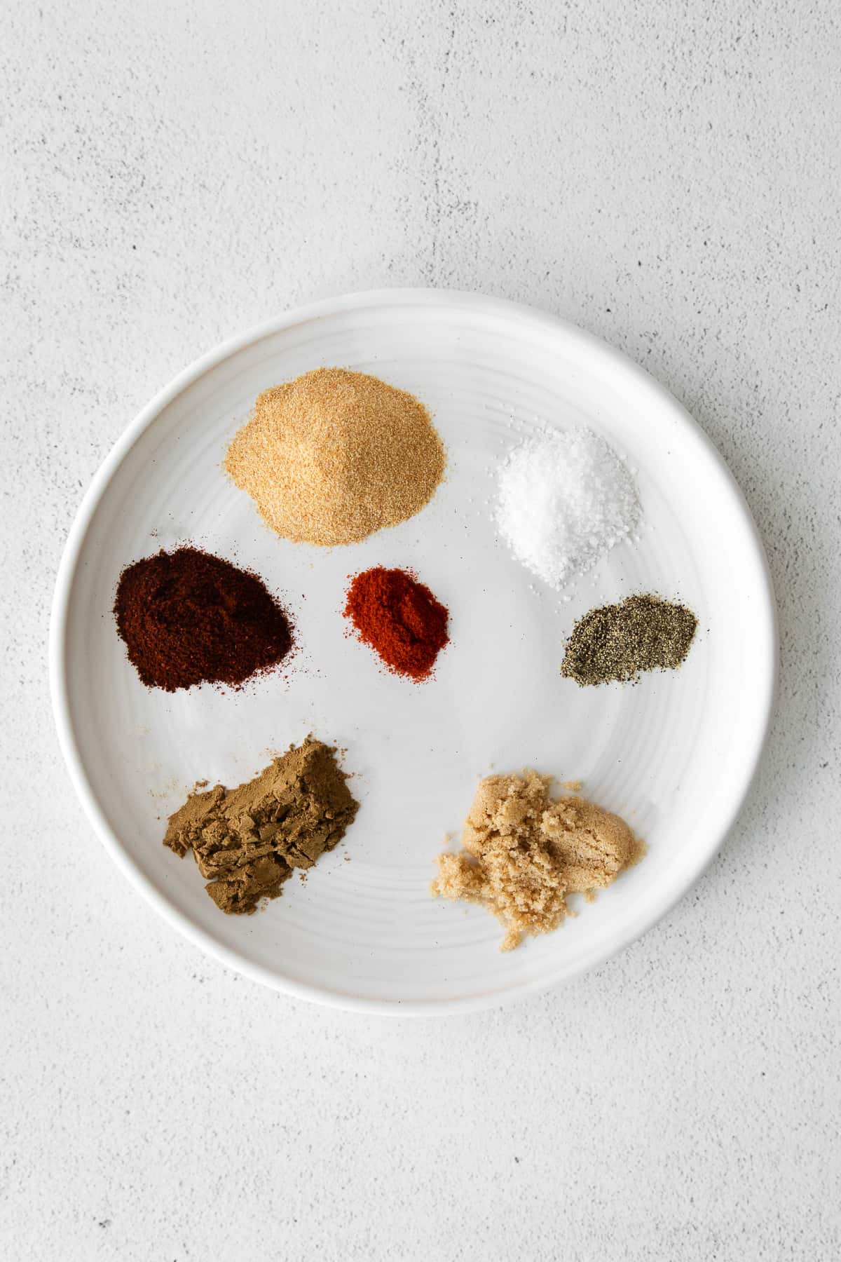 This super flavorful steak taco seasoning comes together in just 7 ingredients you likely have on hand in your spice cupboard already. ingredients for steak taco seasoning on a plate
