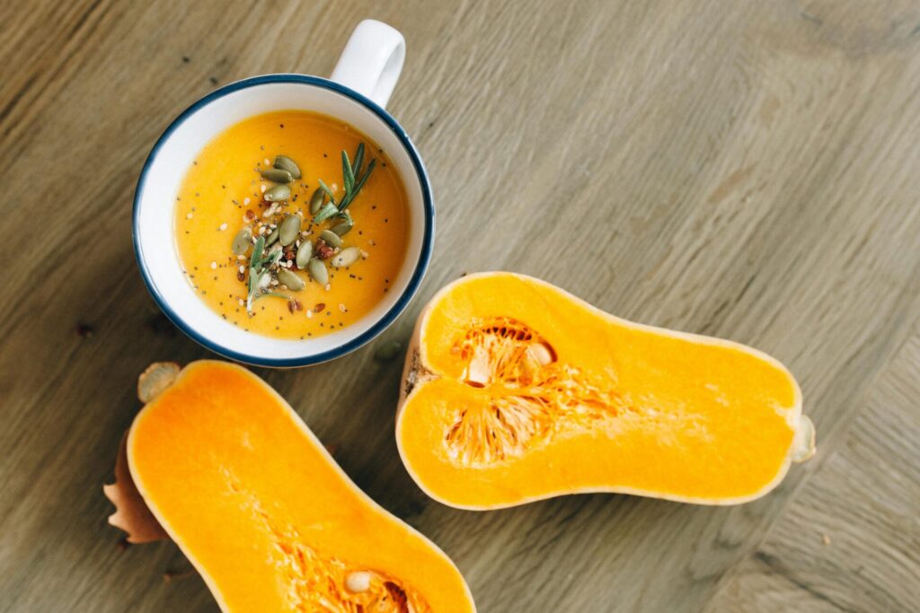 A warm, homemade butternut squash soup garnished with seeds and rosemary.
