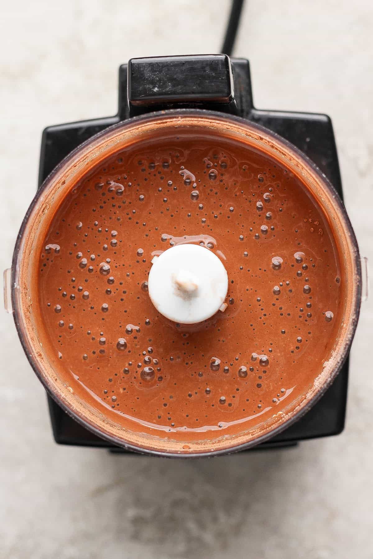 A blender filled with smooth, chocolate-colored liquid viewed from above.