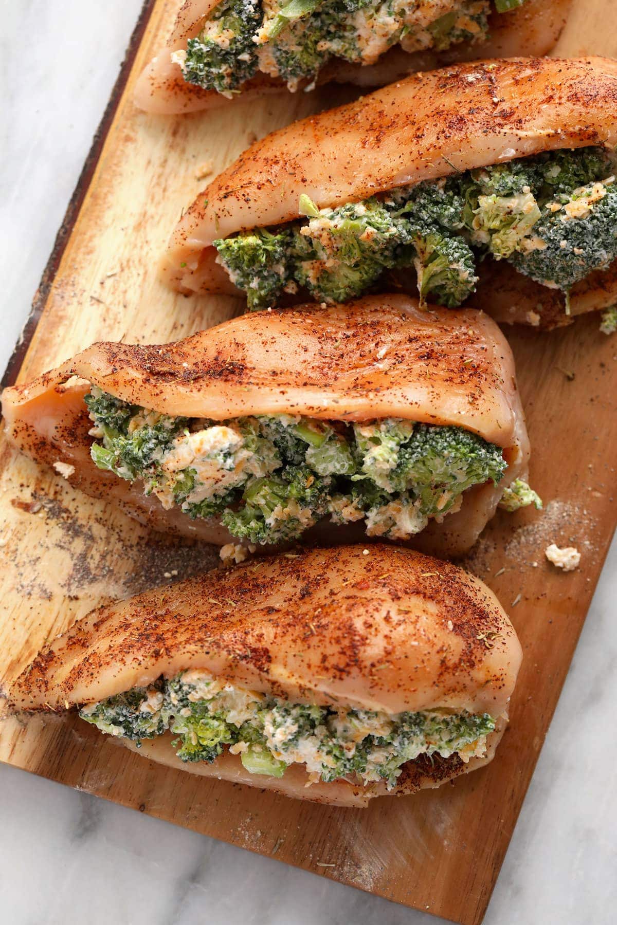 Broccoli and cheese stuffed chicken breast never tasted better! Our super flavorful chicken dry rub and easy broccoli and cheese filling make these stuffed chicken breasts deliciously flavor and protein packed. broccoli and cheese stuffed chicken breasts ready to be seared and then baked.
