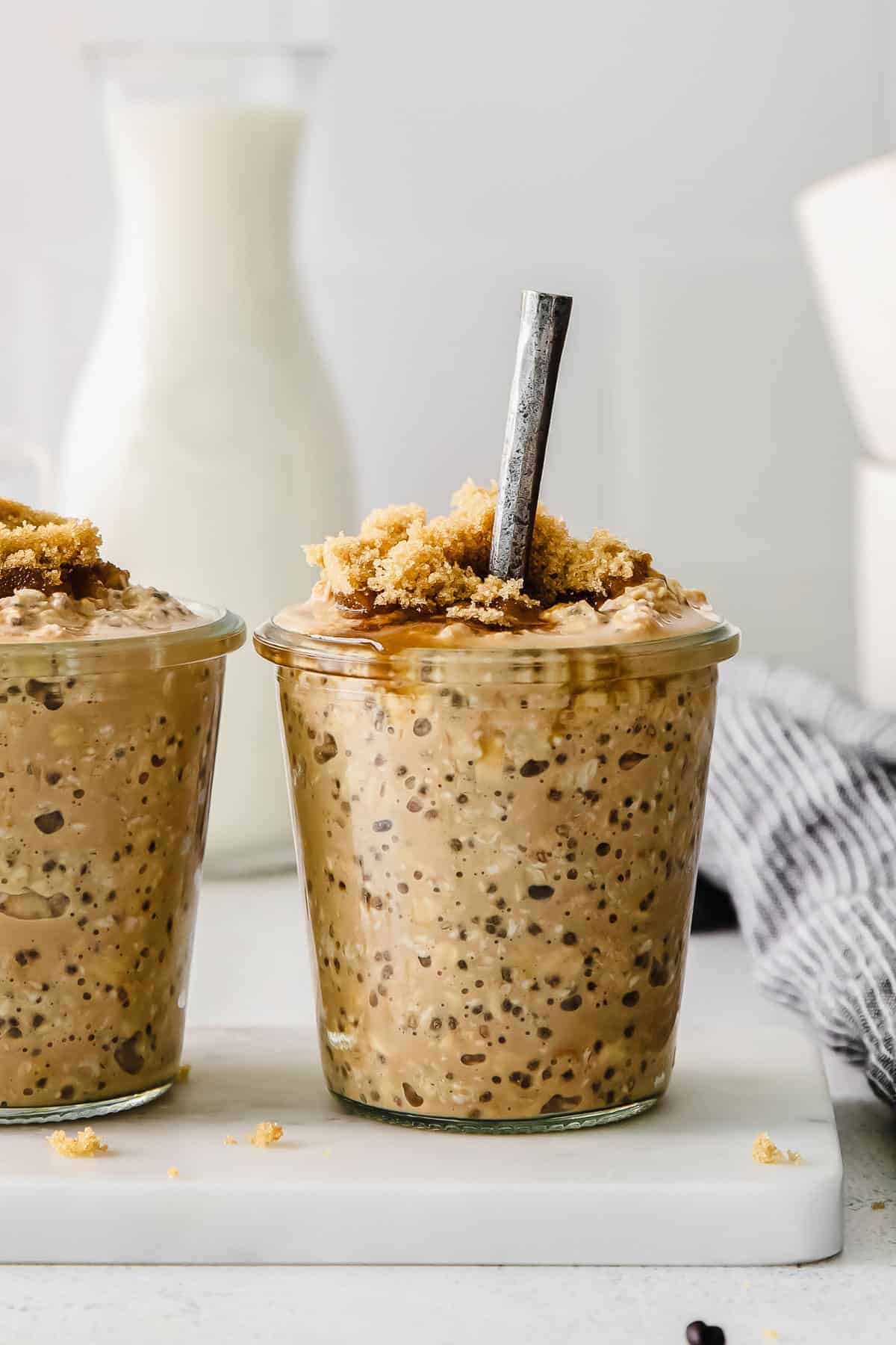 brown sugar shaken espresso overnight oats in a glass jar topped with brown sugar and chia seeds