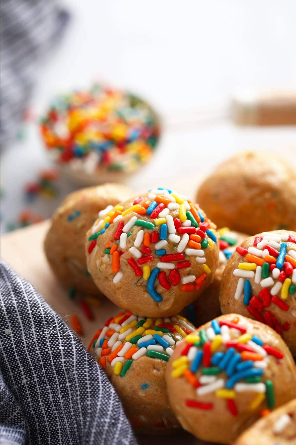 birthday cake protein balls covered in rainbow sprinkles on a plate
