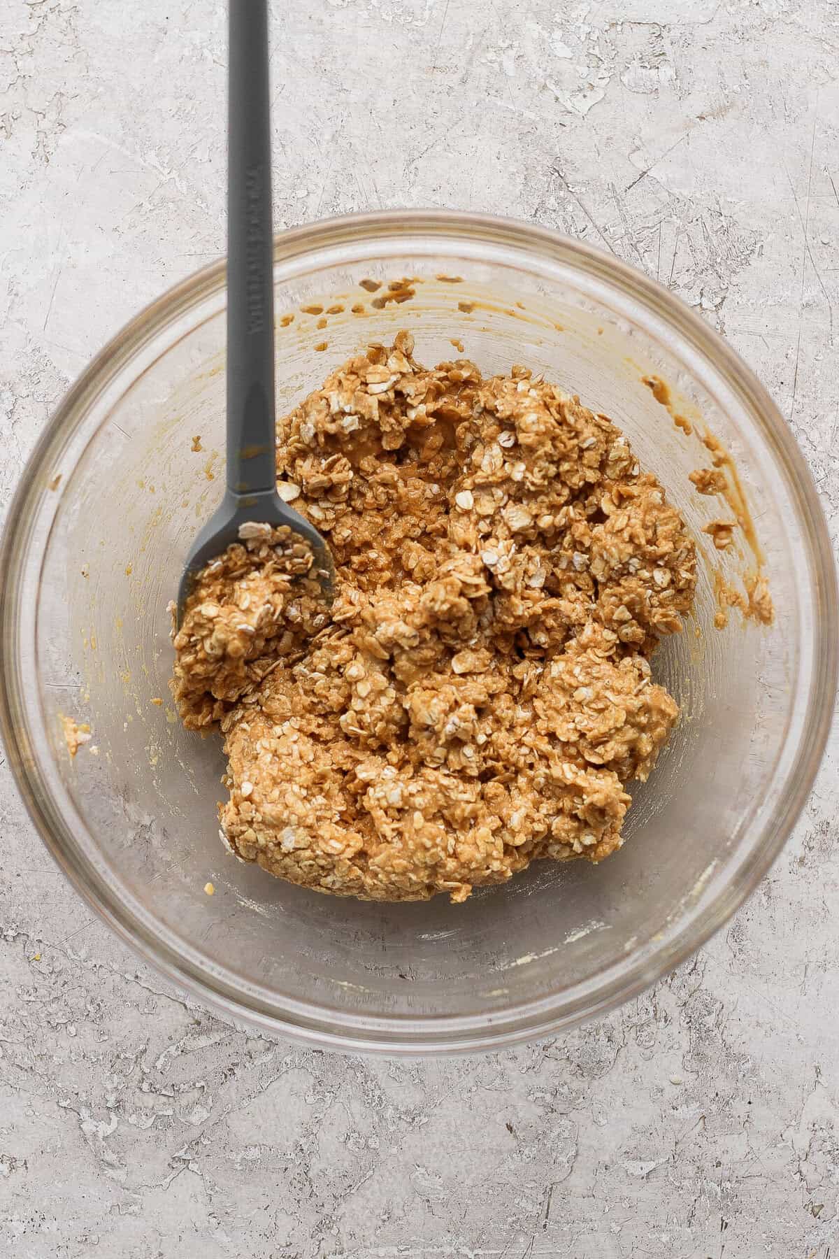 stirring peanut butter oat crumble topping with a spatula until clumpy