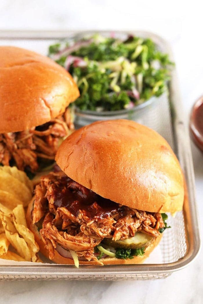 pulled chicken crock pot piled on a bun with chips
