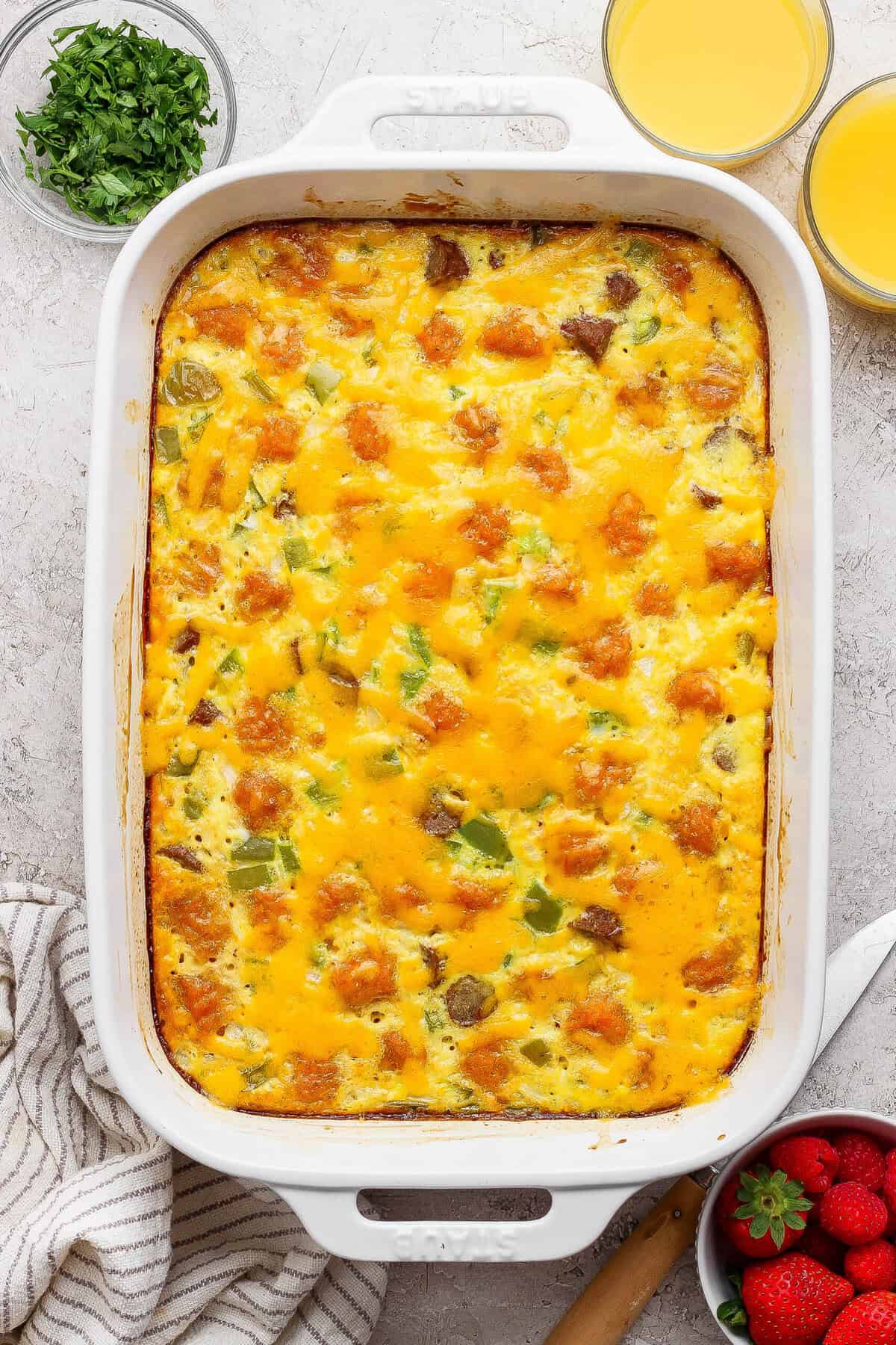 baked sweet potato breakfast casserole with melted cheddar cheese in white dish
