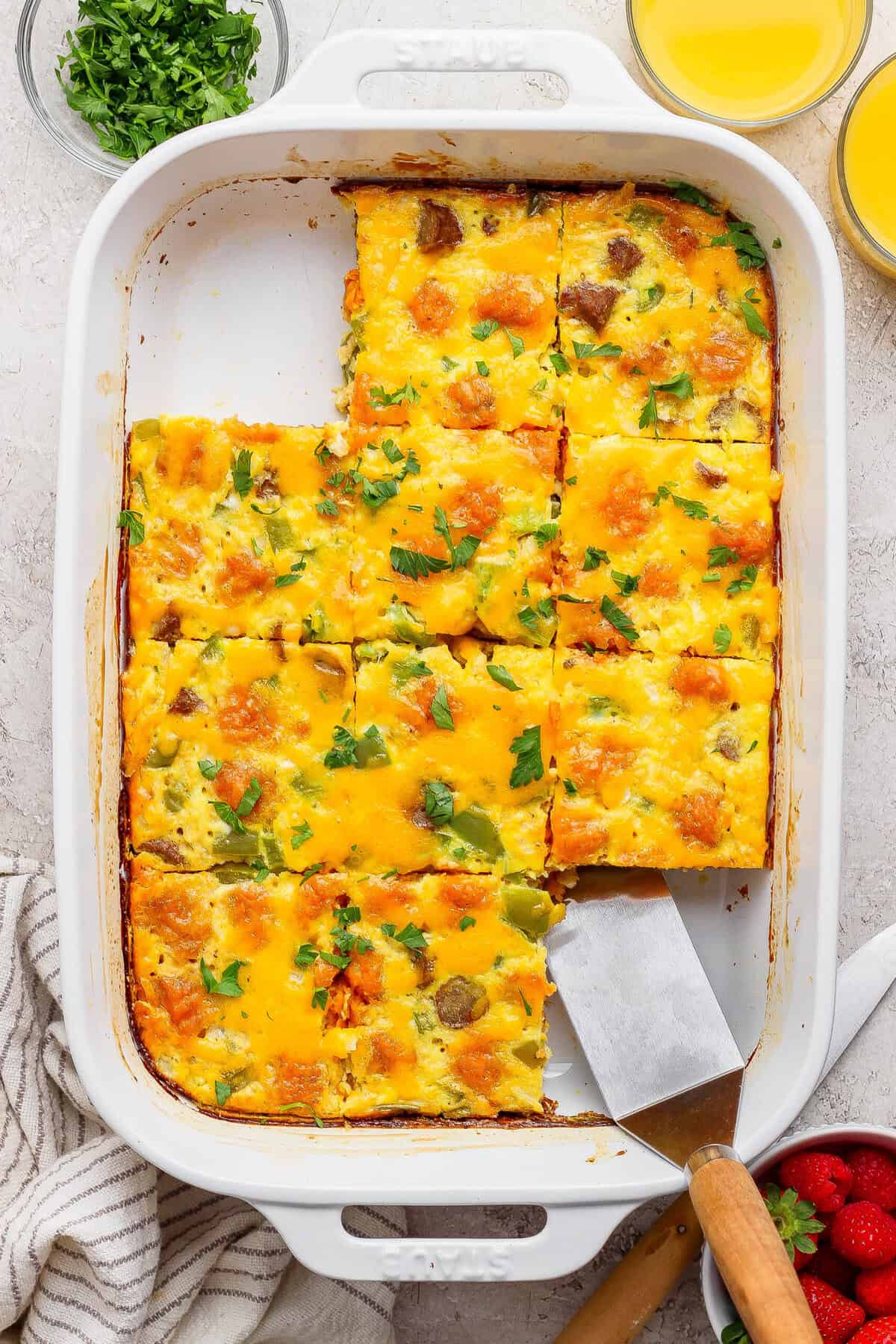 sweet potato breakfast casserole sliced into squares with a piece being lifted out