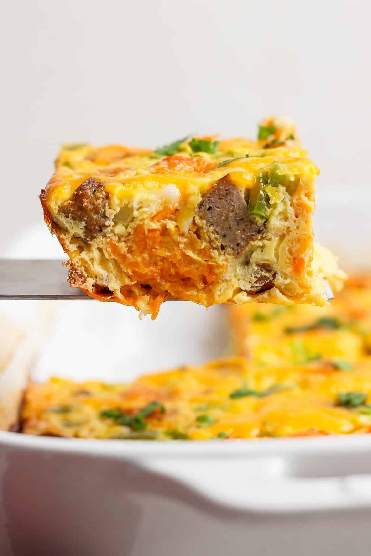 close-up of sweet potato breakfast casserole slice showing tater tots and sausage inside