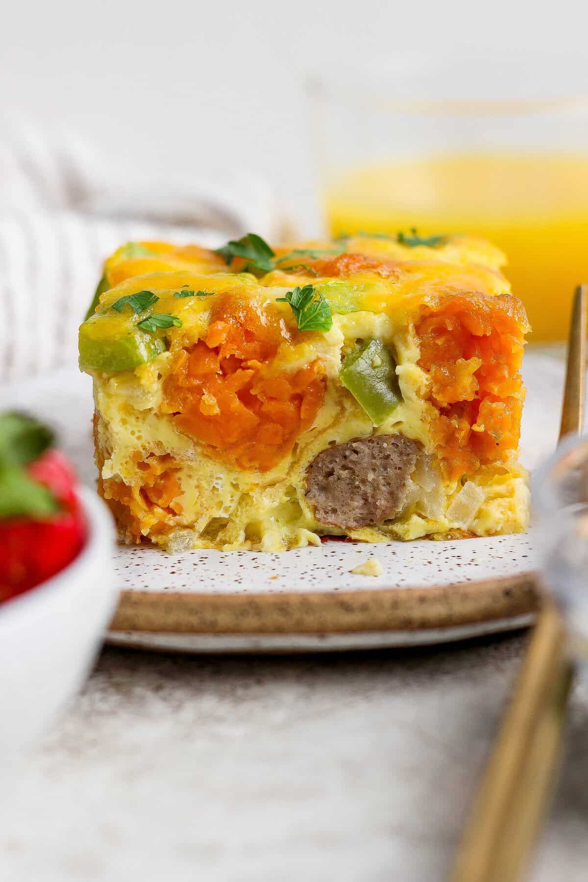 plated slice of sweet potato breakfast casserole showing layers of tater tots and sausage