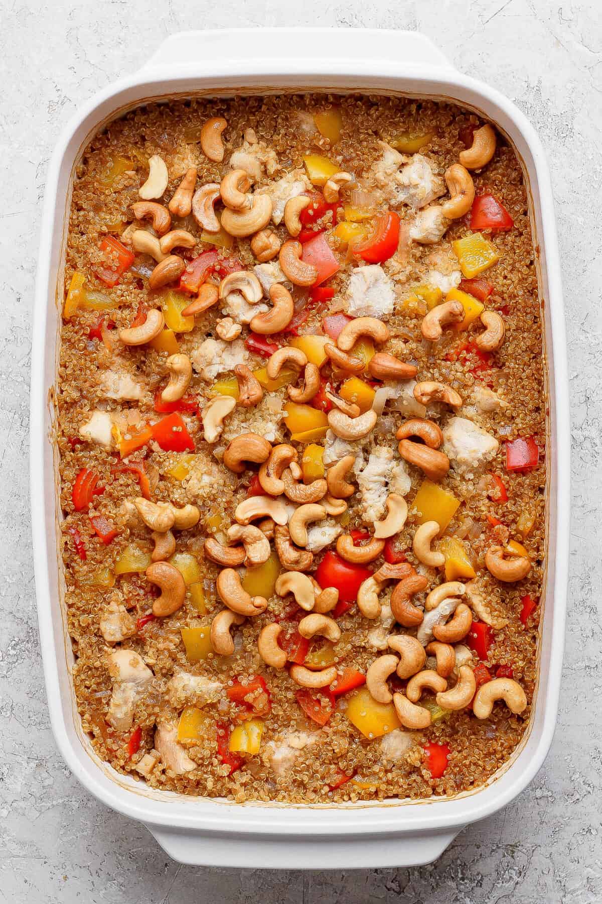 Cashew chicken casserole fresh out of the oven, topped with cashews and bell peppers.