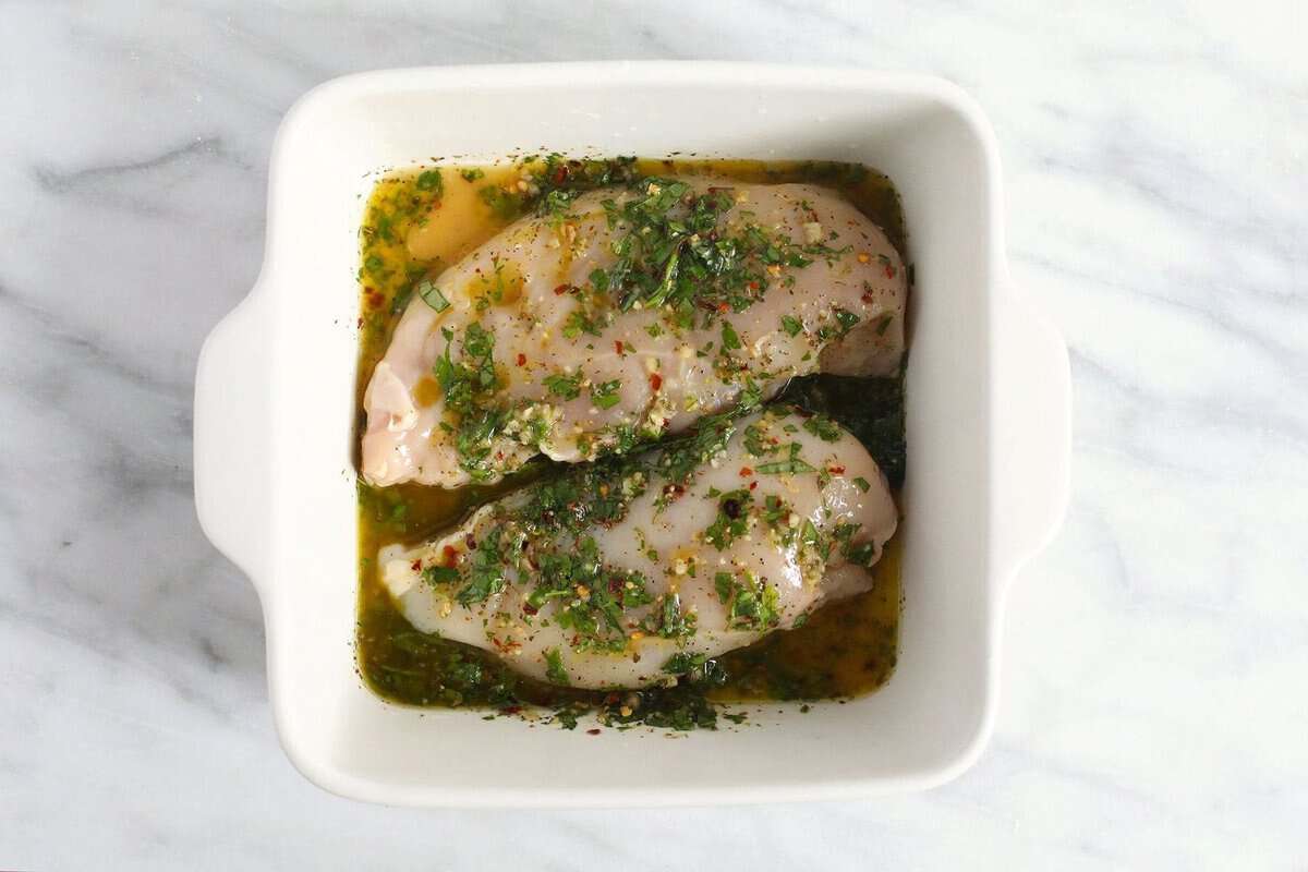 chicken marinating in dish.