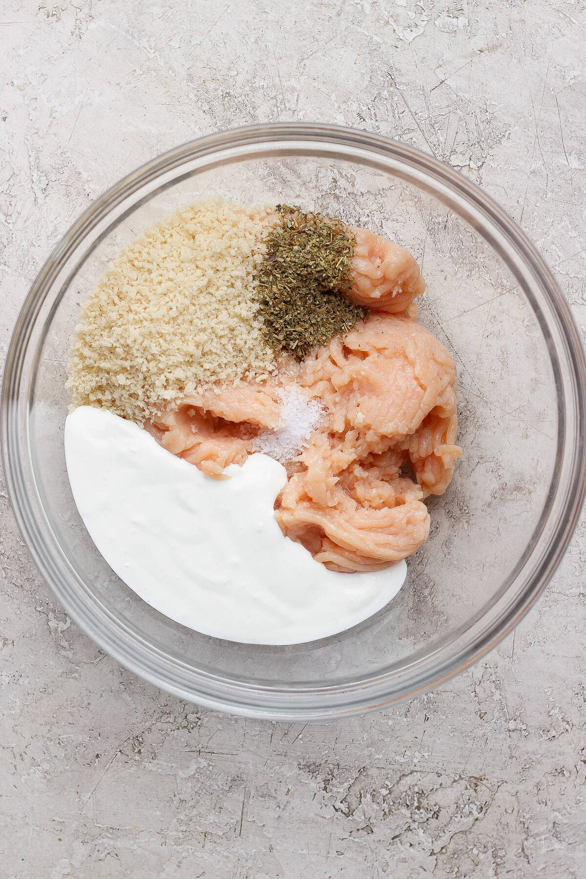 Ground chicken, panko, blended cottage cheese, Italian seasoning, and salt in a glass mixing bowl.