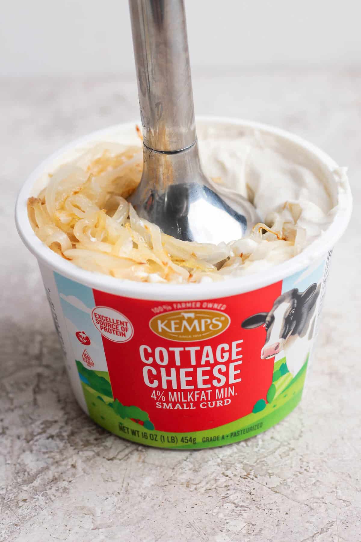 Soft golden onions added to smooth blended cottage cheese dip before pulsing.