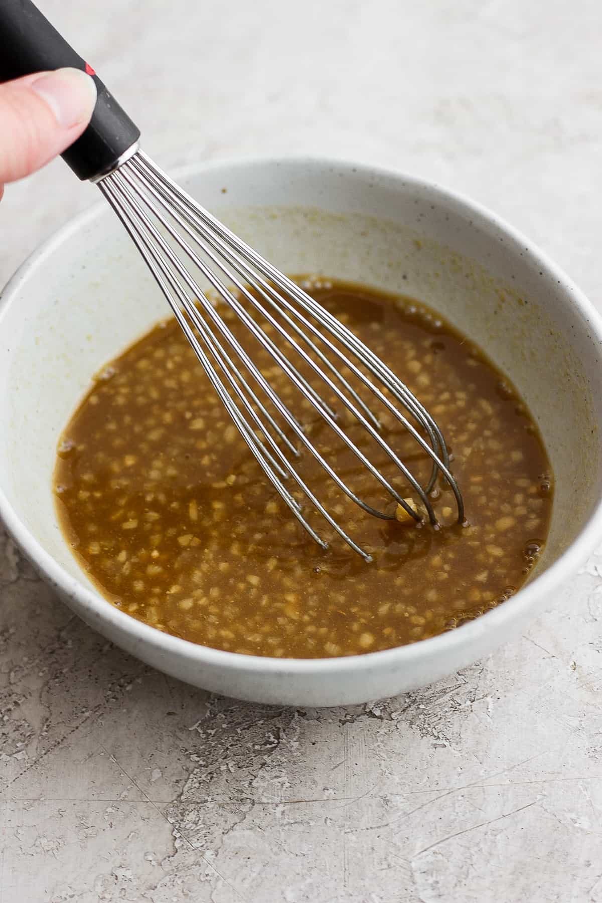 This classic rib marinade recipe is perfectly savory and sweet with only 5 ingredients -- an amazing complement to your baby back ribs. Enjoy! Rib marinade in a bowl with a whisk.