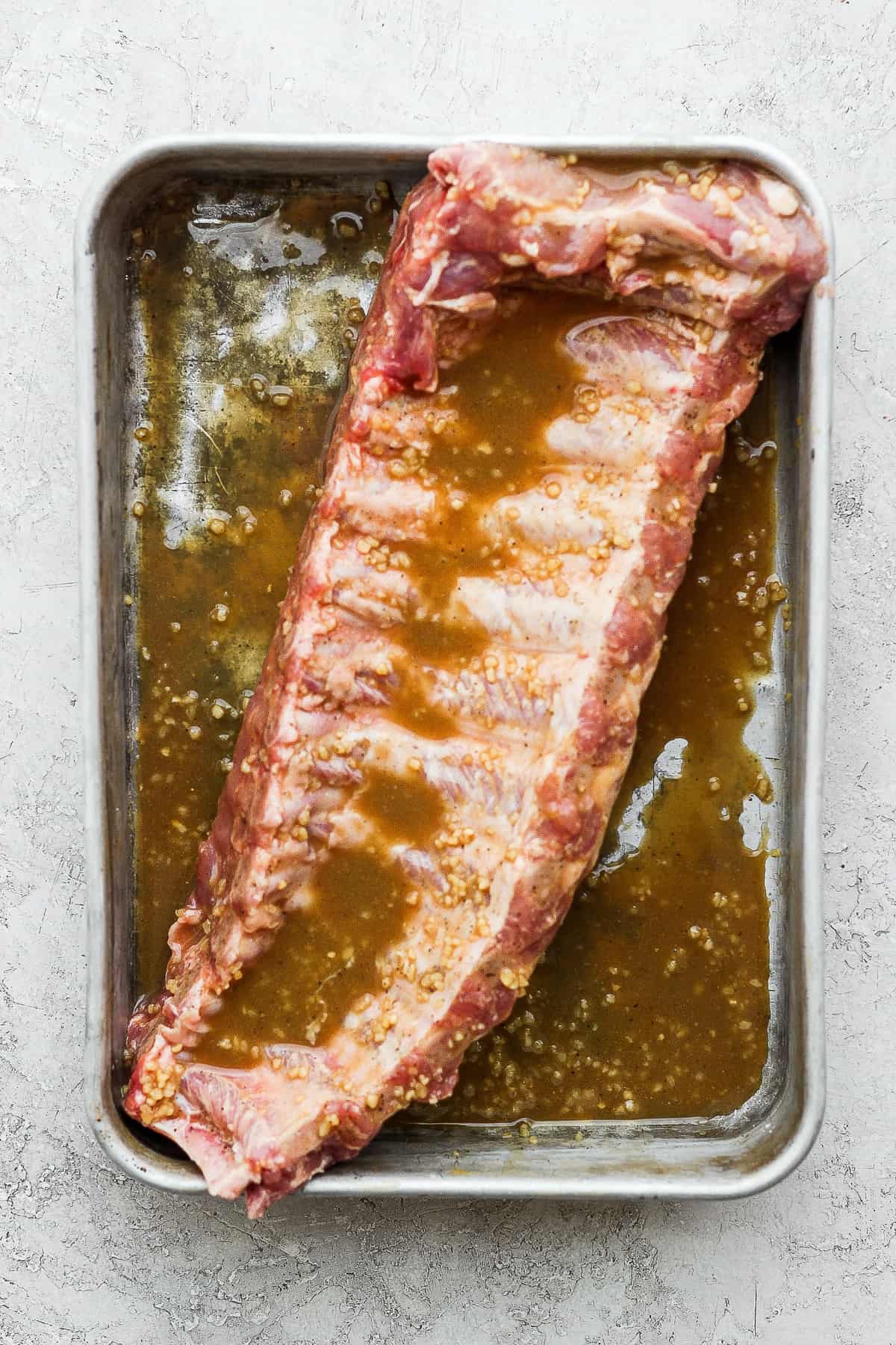 This classic rib marinade recipe is perfectly savory and sweet with only 5 ingredients -- an amazing complement to your baby back ribs. Enjoy! Rack of baby back ribs in a rib marinade.