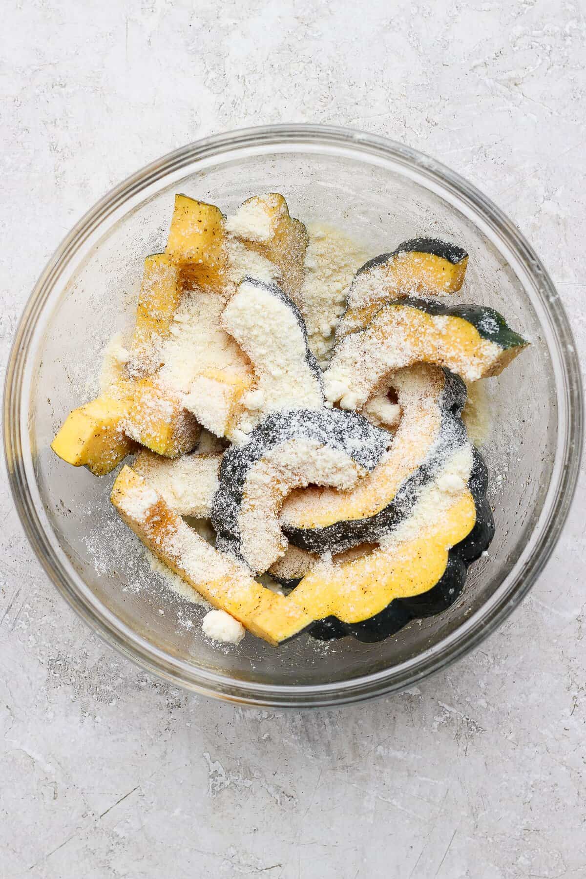 Grated Parmesan sprinkled over acorn squash slices before air frying.