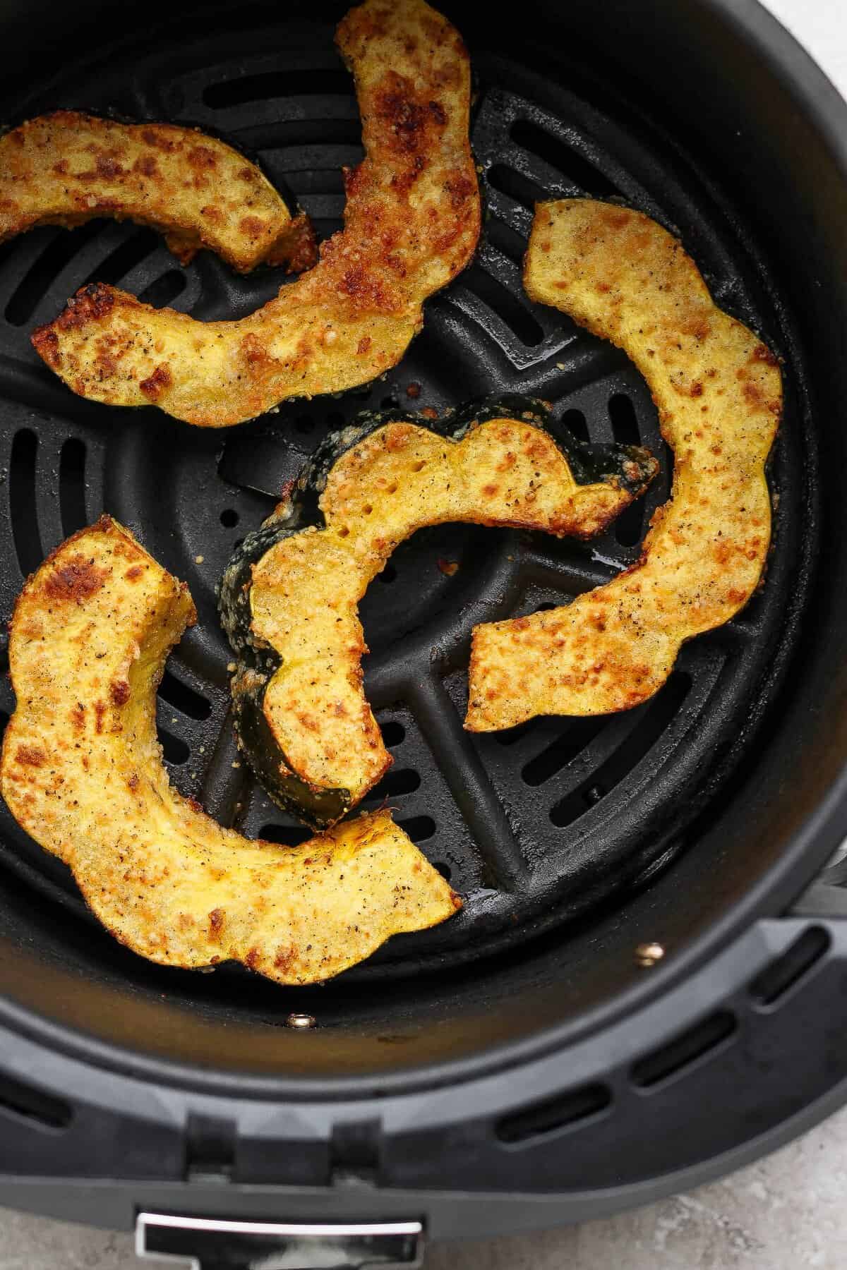 Close-up of the browned Parmesan coating on air-fried acorn squash half-moons.
