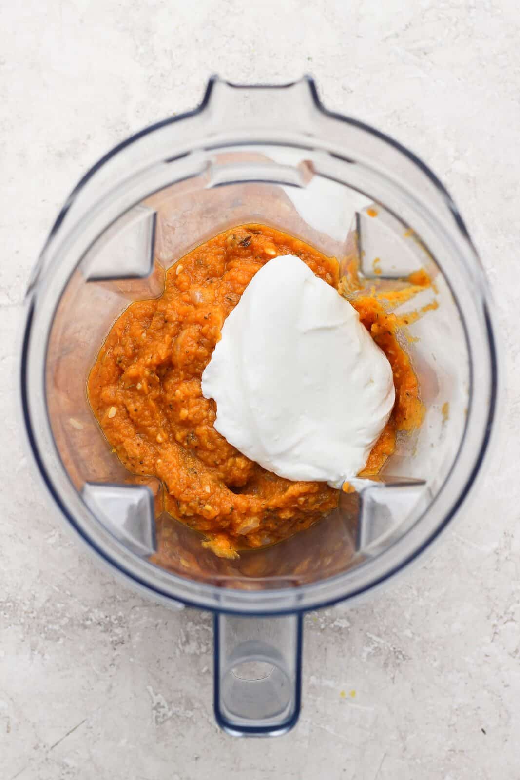 Pumpkin sauce and cottage cheese in a blender before blending.