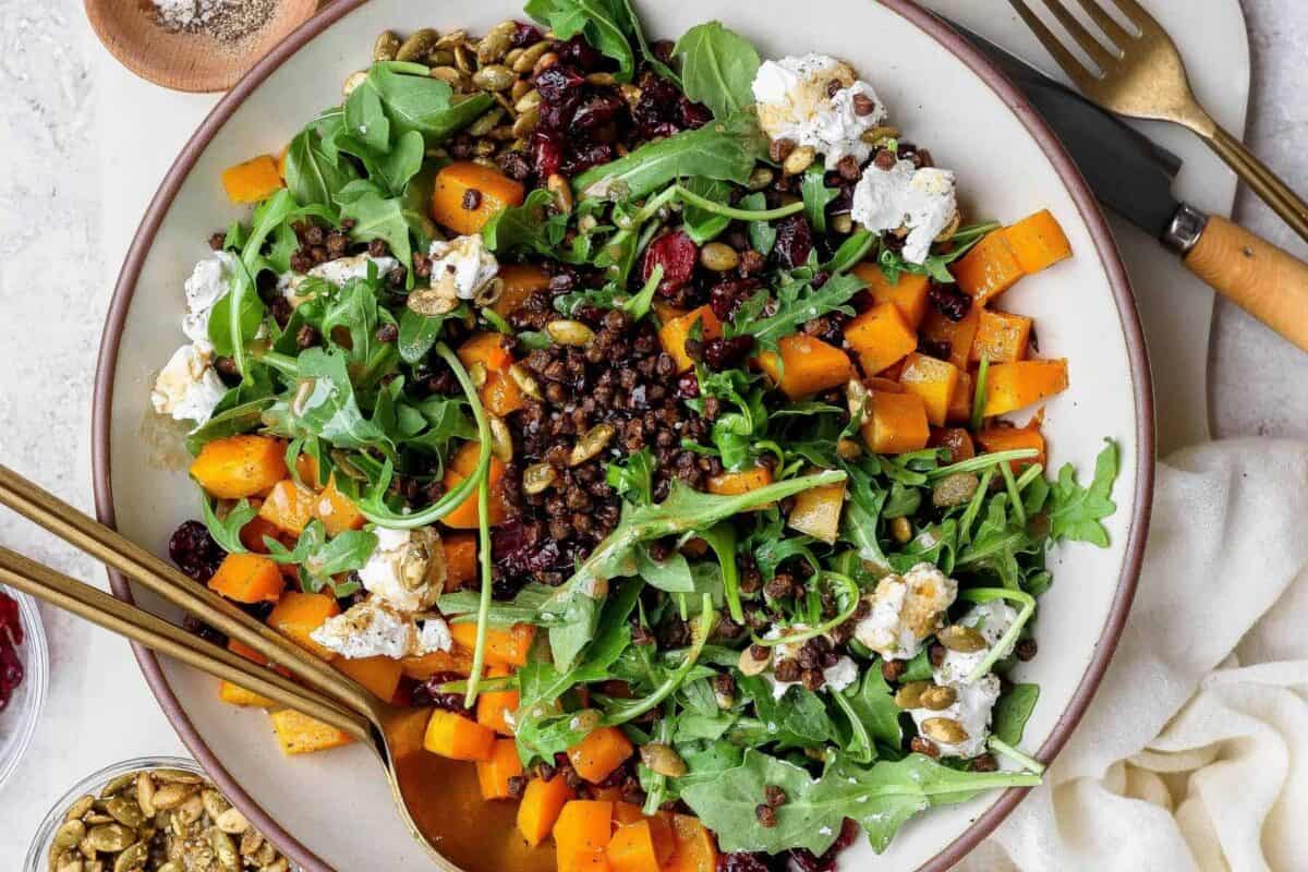 Tossed crispy lentil and butternut squash salad with arugula, goat cheese, dried cranberries, and pepitas.