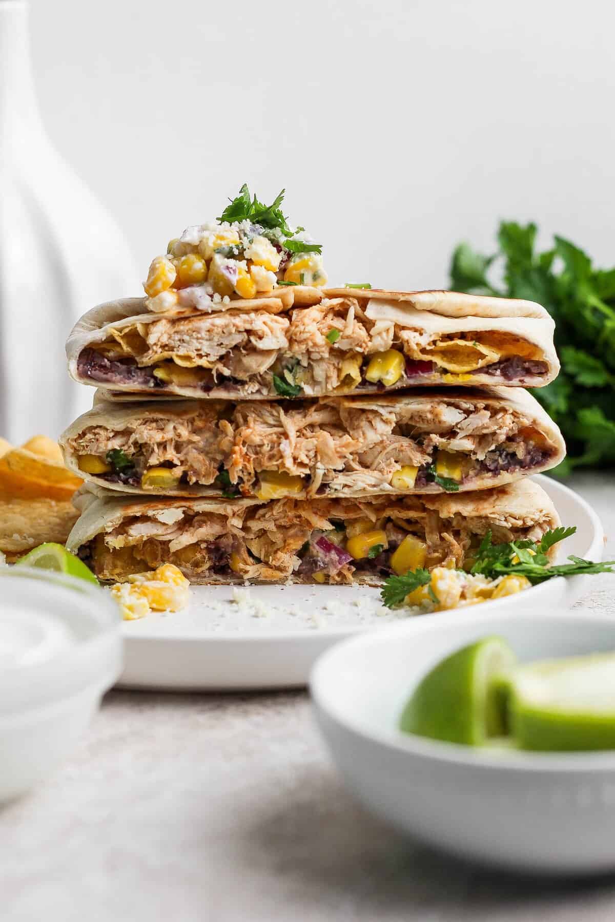 A stack of golden street corn chicken crunchwrap halves with creamy chicken and corn filling.
